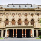 Teatrul Rustaveli are o fațadă neoclasică bogat decorată, cu arcade elegante și coloane impunătoare, simbol cultural și arhitectural al orașului Tbilisi.