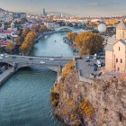Biserica Metekhi se înalță pe o stâncă deasupra râului Kura, încadrând podurile și skyline-ul orașului Tbilisi într-un decor urban spectaculos.