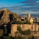Bastioanele Cetății Narikala se înalță pe stâncă, cu ziduri impunătoare și turnuri vechi, dominând Tbilisi cu un farmec atemporal.