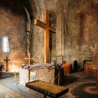 Interiorul Bisericii Jvari: un spațiu auster și sugestiv, cu cruci din lemn, icoane sacre și ziduri vechi de piatră ce păstrează secole de spiritualitate creștină georgiană.