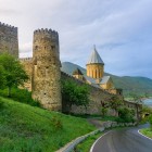 Drumul care duce la Fortăreața Ananuri traversează coline verzi și ajunge la turnuri medievale și biserici din piatră ce domină pitorescul lac Zhinvali, în inima Georgiei.