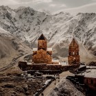 Biserica Sfânta Treime din Gergeti (Tsminda Sameba) domină peisajele Marelui Caucaz, lângă satul Gergeti, la poalele Muntelui Kazbek, simbol iconic al Georgiei.