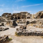 Locuințe antice săpate în stâncă în orașul rupestru Uplistsikhe, unul dintre cele mai fascinante situri arheologice din Georgia, martor al civilizațiilor milenare.