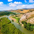Vedere aeriană a orașului rupestru Uplistsikhe, veche așezare săpată în stâncă ce domină râul Mtkvari, înconjurată de dealuri și peisaje spectaculoase din Georgia.