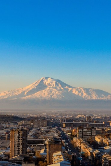 Priveliște panoramică la răsărit cu Muntele Ararat ridicându-se maiestuos deasupra cartierului Sebastia-Malatia din Erevan, Armenia, luminând orașul în culorile calde ale dimineții.