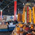 Tarabă din piața GUM din Erevan plină de fructe uscate, dulciuri tradiționale și specialități locale, cu culori vii și arome autentice în capitala Armeniei.