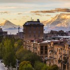 Priveliște panoramică asupra Erevanului cu Muntele Ararat în fundal. La răsărit, orașul strălucește în tonuri calde sepia, cu efect vintage.