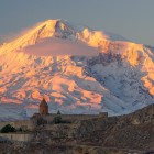 Priveliște spectaculoasă a Mănăstirii Khor Virap cu mărețul Munte Ararat în fundal, în lumină aurie și peisaje emblematice ale Armeniei.