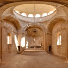 Interiorul Mănăstirii Noravank, Armenia: arhitectură medievală elegantă cu arcade și cupolă centrală, lumină naturală și atmosferă mistică, plină de istorie.