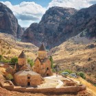 Mănăstirea Noravank în canionul Vayots Dzor, Armenia: complex medieval din piatră roșie, înconjurat de munți spectaculoși, simbol al istoriei și spiritualității.