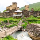 Vedere a satului Ushguli la poalele muntelui Shkhara, cu turnuri din piatră și case vechi. Un sat pitoresc din Svaneti, în peisaje montane spectaculoase.