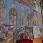 Fresce medievale în Mănăstirea Akhtala, Armenia, cu figuri sacre pictate pe pereți de piatră, reflectând tradițiile religioase și artistice ale Caucazului.