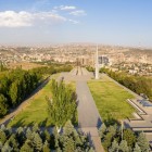 Vedere asupra memorialului Tsitsernakaberd din Yerevan, simbol al Genocidului Armean, situat într-un parc cu alei împădurite și panoramă asupra orașului.