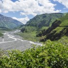 Vedere asupra Defileului Dariali din districtul Kazbegi: un canion spectaculos format de râul Terek, la granița dintre Georgia și Rusia, cu stânci abrupte și natură sălbatică.