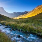 Un pârâu cristalin curge printre pajiști alpine și văi line, la poalele Muntelui Chaukhebi, oferind un peisaj spectaculos în inima Caucazului georgian.