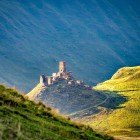 Ruinele unei fortărețe antice în Valea Truso, cocoțată pe o colină panoramică printre vastele peisaje montane ale Caucazului georgian.