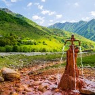 Izvor mineral în Defileul Khada, unde apele bogate în fier ies la suprafață printre pajiști alpine și munții verzi ai Caucazului georgian.