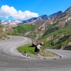 Curbă panoramică a Drumului Militar Georgian lângă Stepantsminda, acces către Valea Truso și punct de plecare pentru trekking prin peisajele spectaculoase ale Caucazului.