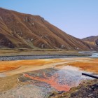 Travertine roșiatice și izvoare minerale în Valea Truso, unde oxidul de fier colorează solul și creează peisaje naturale neobișnuite.