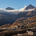 Vedere panoramică asupra Gudauri la apus, cu satul așezat printre Munții Caucazului Mare, într-unul dintre cele mai spectaculoase peisaje din Georgia.