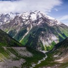 Priveliște asupra Muntelui Dalakhora și văii râului Mestiachala, între pante verzi și stânci abrupte. Un peisaj amplu și natural în inima Svaneti.