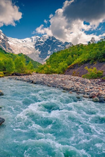 Apele albastre ale raului Adishchala curg lin sub muntele Shkhara, in timp ce lumina diminetii dezvaluie Svaneti si satul linistit Adishi.