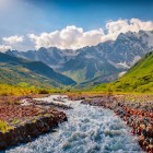 Un râu de munte curge la poalele ghețarului Tetnuldi, în lumina clară a verii. Din pasul Chkhunderi se deschid priveliști largi asupra Svanetiului de Sus și a vârfurilor Caucazului.