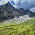 Priveliște asupra muntelui Dolomisitsveri din lanțul Marelui Caucaz, în regiunea Racha-Lechkhumi. Creste stâncoase și pante verzi conturează peisajul.