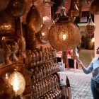 Pe străzile Medinei din Marrakech, magazinele și felinarele creează atmosfere calde și autentice în inima Marocului.