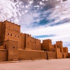 Prim-plan cu Kasbah Taourirt, între ziduri din pământ roșiatic, turnuri și detalii ce reflectă arhitectura berberă din sudul Marocului.