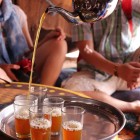 Degustare în satul Khamlia a clasicului ceai marocan preparat cu ceai verde, frunze proaspete de mentă și mult zahăr.