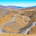 Pasul montan Tizi n'Tichka traversează Munții Atlasului Mare și oferă priveliști spectaculoase spre văi, sate berbere și vârfuri stâncoase din Maroc.