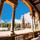 Din galeriile elegante ale Pieței Spaniei se dezvăluie una dintre cele mai emblematice priveliști din Sevilla, între poduri spectaculoase și farmec andaluz autentic.