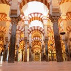 Pădurea impresionantă de coloane și arcade bicolore transformă Moscheea-Catedrală din Córdoba într-o capodoperă a Andaluziei, unde arta islamică întâlnește istoria.