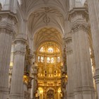 Navele impunătoare ale Catedralei din Granada conduc spre magnificul altar aurit, unde arta renascentistă, spiritualitatea și istoria se îmbină în deplină armonie.