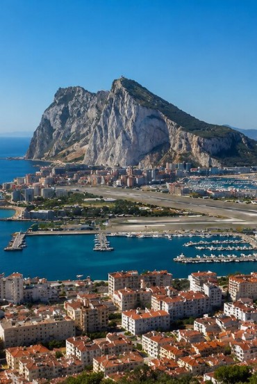 Stânca Gibraltar domină peisajul prin impresionantele sale faleze calcaroase, privind spre port și strâmtoarea care leagă Marea Mediterană de Oceanul Atlantic.