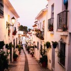 Una dintre străzile reprezentative din Mijas se remarcă prin case albe, balcoane cu flori și pavaj din piatră, oferind imagini autentice pe Costa del Sol.