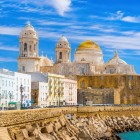 Catedrala Santa Cruz pe Mare domină panorama orașului Cádiz, privind spre Oceanul Atlantic printre ziduri istorice, case albe și farmecul centrului vechi.