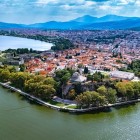 Vedere aeriană asupra peninsulei istorice din Ioannina, înconjurată de apele lacului Pamvotida. Zidurile vechi, cetatea și vegetația oferă unul dintre cele mai frumoase peisaje din Epir.