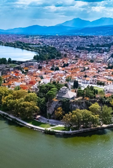 Vedere aeriană asupra peninsulei istorice din Ioannina, înconjurată de apele lacului Pamvotida. Zidurile vechi, cetatea și vegetația oferă unul dintre cele mai frumoase peisaje din Epir.