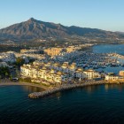 Puerto Banús se dezvăluie de sus prin iahturi de lux, ape turcoaz și arhitectură mediteraneană elegantă. Muntele La Concha completează panorama spectaculoasă a orașului Marbella.