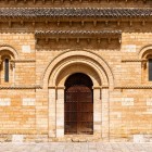 Portalul romanic al Bisericii San Martín de Tours îi întâmpină pe pelerini cu eleganță atemporală, detalii sculptate și piatra aurie a secolului al XI-lea.