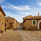 O stradă pietruită traversează Castrillo de los Polvazares, printre case vechi din piatră și peisaje autentice ce păstrează spiritul Camino de Santiago.