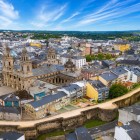 Vedere aeriană asupra centrului istoric din Lugo, dominat de Catedrala Santa Maria și impunătoarele ziduri romane incluse în patrimoniul UNESCO, simboluri ale Galiciei.