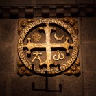 Vechile cruci de consacrare ale Catedralei din Santiago, cu Alfa, Omega, soarele și luna, amintesc de consacrarea bazilicii și îl simbolizează pe Hristos ca începutul și sfârșitul tuturor lucrurilor.
