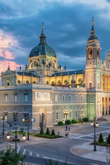 Catedrala Almudena domină centrul Madridului prin fațada neoclasică, turnurile gemene și cupola sa, îmbinând formele istoriste în armonie cu Palatul Regal din apropiere.