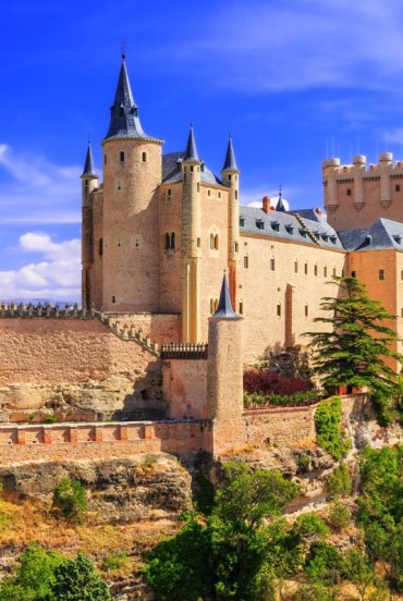 Alcázarul medieval din Segovia domină orașul de pe un promontoriu stâncos. Turnurile, zidurile și acoperișurile din ardezie spun povestea Castiliei.