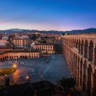La apus, Apeductul Roman din Segovia domină Plaza Oriental prin impresionantele sale arcade din granit, oferind una dintre cele mai frumoase priveliști din Castilia.