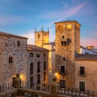 La apus, Plaza de San Jorge dezvăluie centrul vechi al orașului Cáceres, dominat de turnul Palatului Los Golfines de Abajo, în centrul istoric UNESCO al Extremadurei.