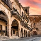 Arcadele din piatră ale orașului Trujillo conduc privirea spre Biserica San Martín, iar lumina apusului pune în valoare arcurile, logiile și fațadele istorice din Extremadura.